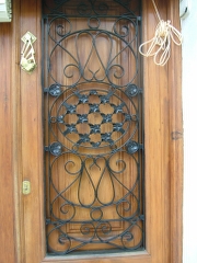 Reja para puertas de madera rustica y de buen estilo con adornos de forja bien trabajada ideal para puertas de madera.